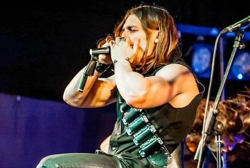 long-haird man playing the harmonica on stage