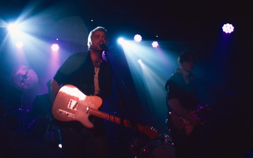 Yasha 96 live, with colourful stage lights behind