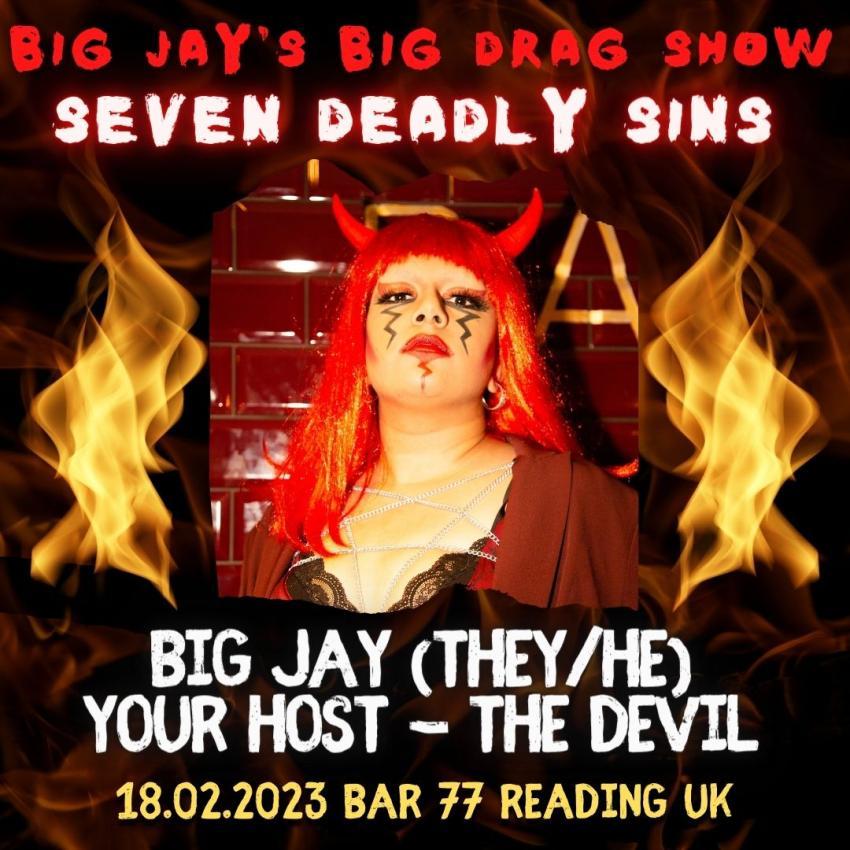 Photo of Big Jay the drag artist, dressed as the Devil with a red wig and horns, looking down at the camera in an attempt to be intimidating or something. Red eyeshadow, red lipstick, black eyeliner