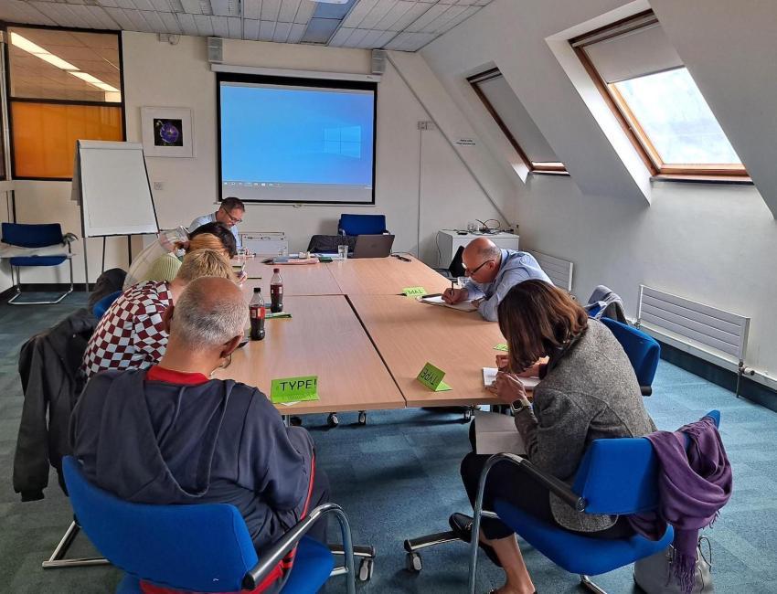 people writing on papers around a desk