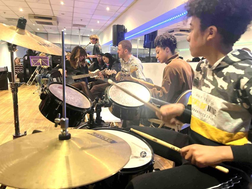 Young boy learning to play drums in a music class 