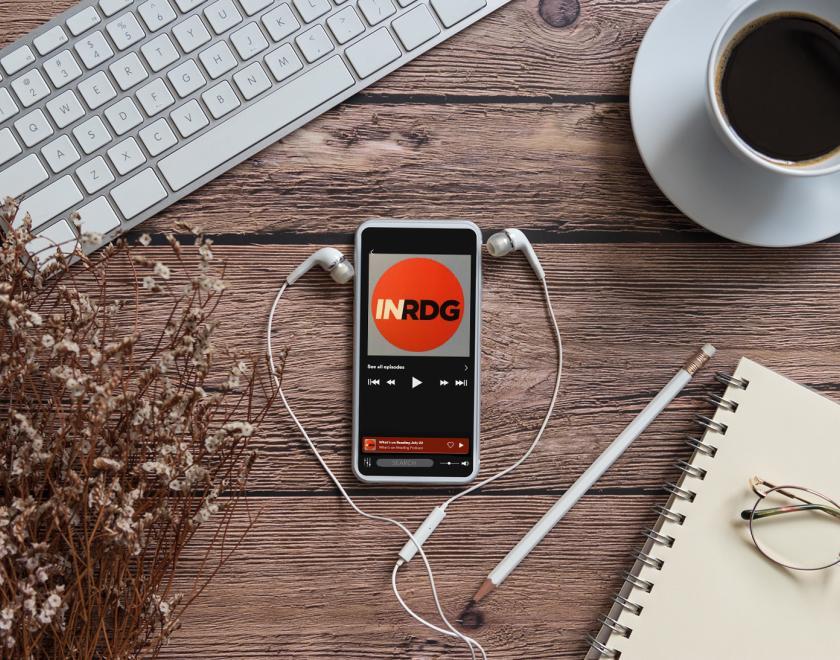 Desk with smartphone tuned to What's On Reading podcast