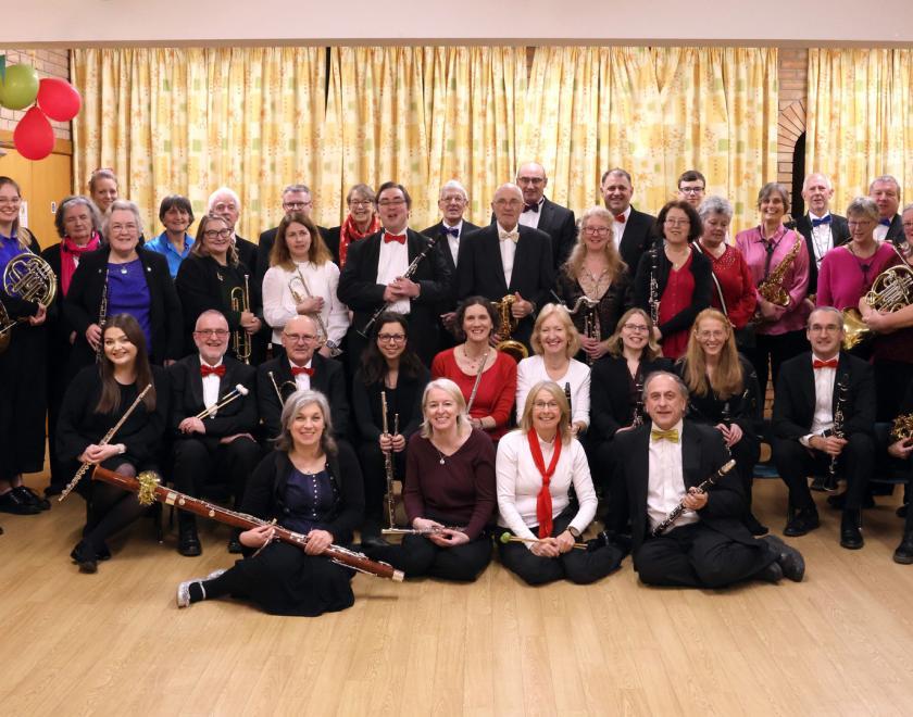 musicians lined up in two row, all holding their instruments and smiling at the camera