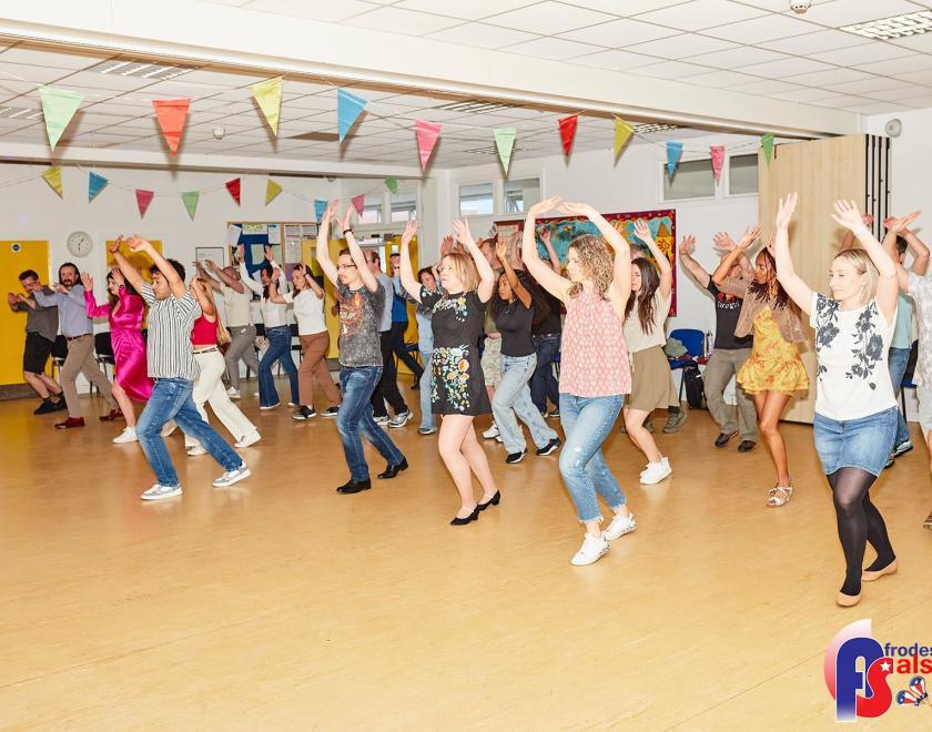 groupd of people dancing salsa in line with the arms up