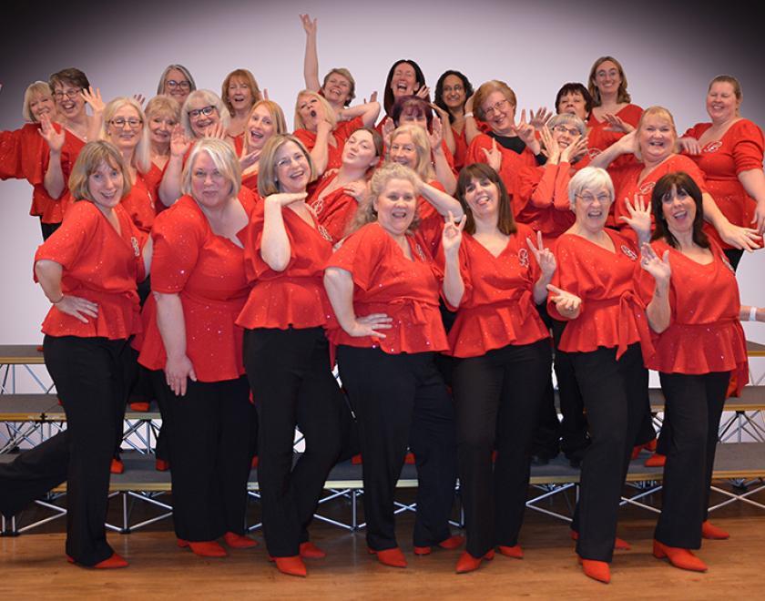 Female choir the Barbarettes in red tops and black trousers