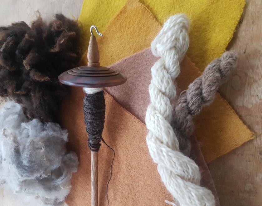 A picture of a spindle, hand spun wool and plant dyed wool felt