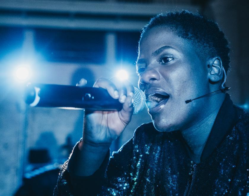 Close-up photo of Lady Lykez singing or speaking into a microphone