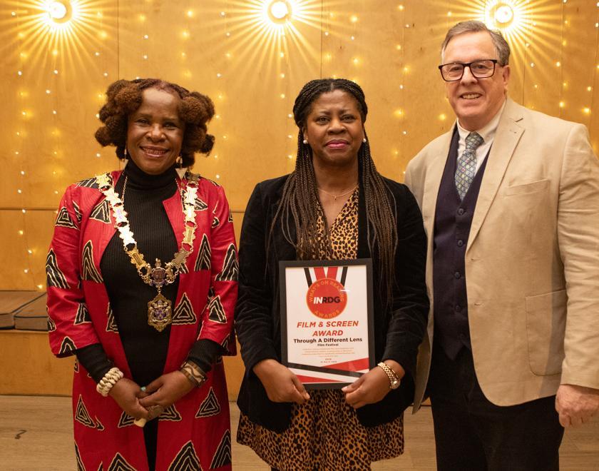 Jocelyn Chandler-Hawkins of Through A Different Lens poses with the Film & Screen Award certificate alongside presenter Nigel Horton Baker and the Mayor of Reading