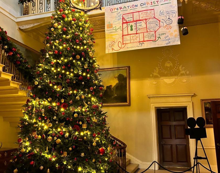 room in Basildon Park decorated with a Christmas tree and ephemera that represents the film Home Alone