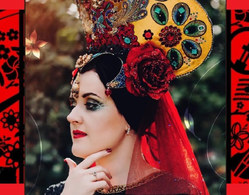 Colourful image of the singer Daria Kulesh. Daria is looking to the side with her chin resting on her hand. Daria's eyes are made up with dark, dramatic colours, and her lips are red. Daria also has red streaks in her black hair and her hair is decorated with a red flower shape. Around the photograph black shapes of instruments, musical notes and flowers are against a red background that echoes Daria's colours.