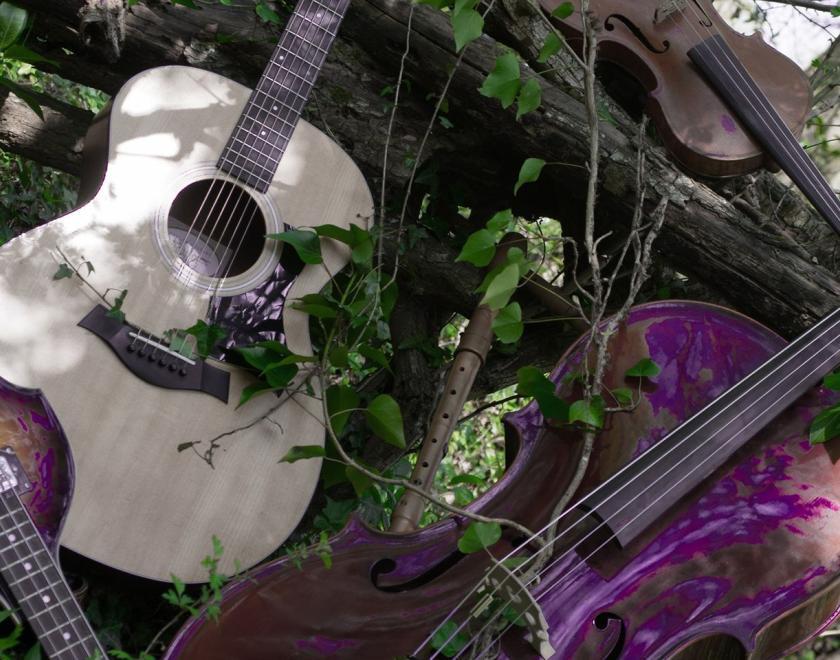 Musical instruments nestle amongst ivy clad branches