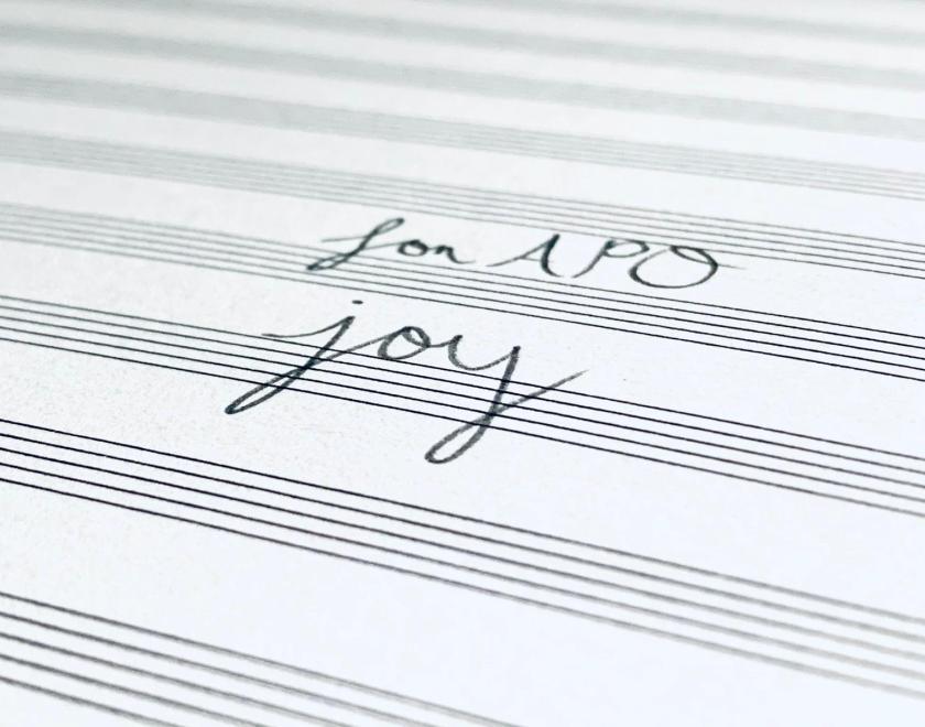 A handwritten text: For APO Joy on the music score