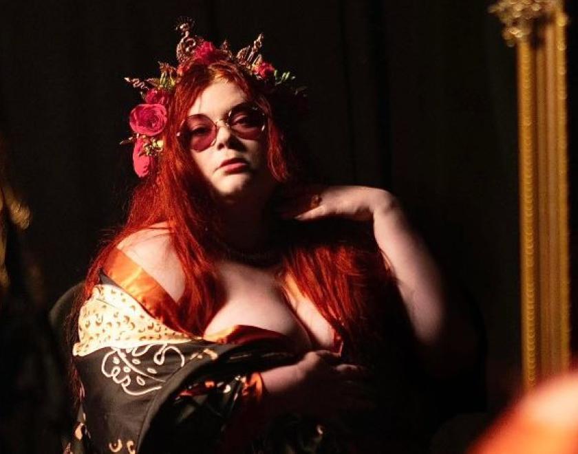 Photo of Alice Armstrong with red hair and black glasses