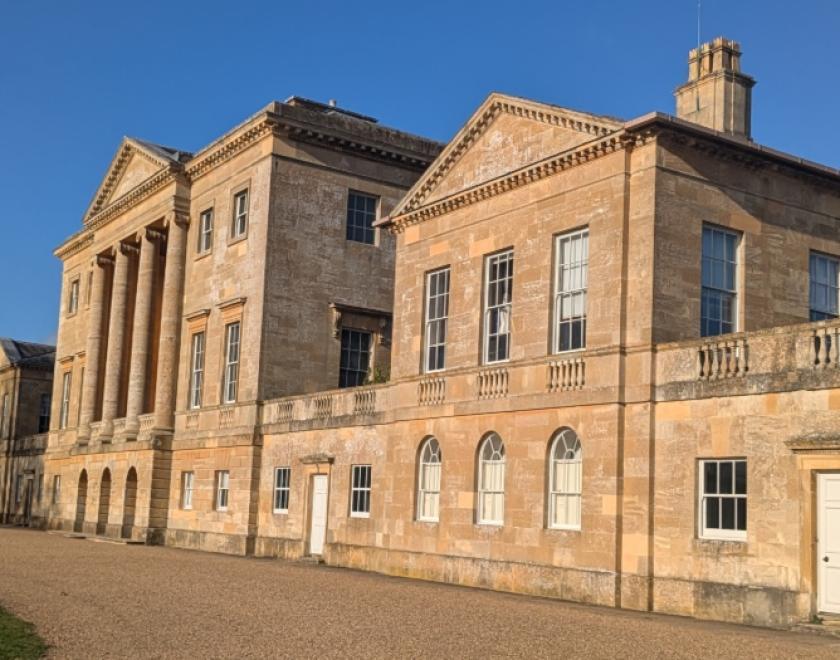 The front of Basildon Park manor house in the sunshine with a beautiful blue sky.