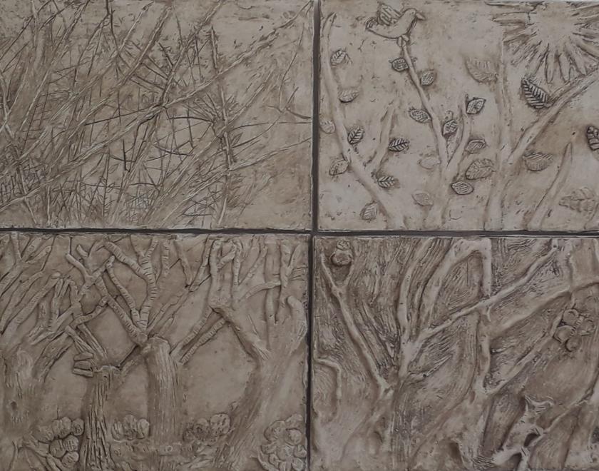 White relief artwork showing trees in four seasons