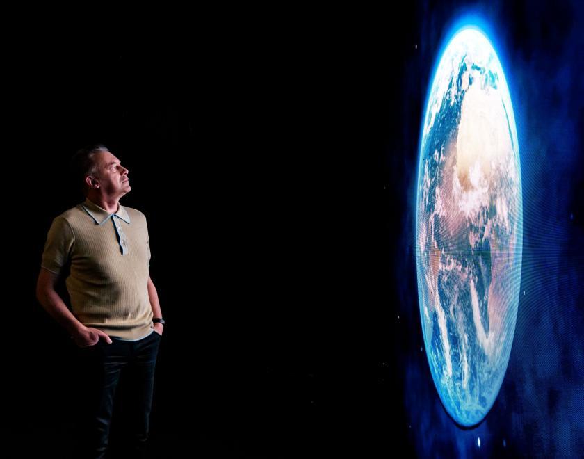 Chris Packham contemplates a large image of the planet Earth