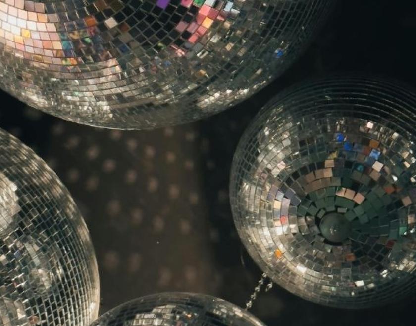 The image shows a close up of different sized silver disco balls.