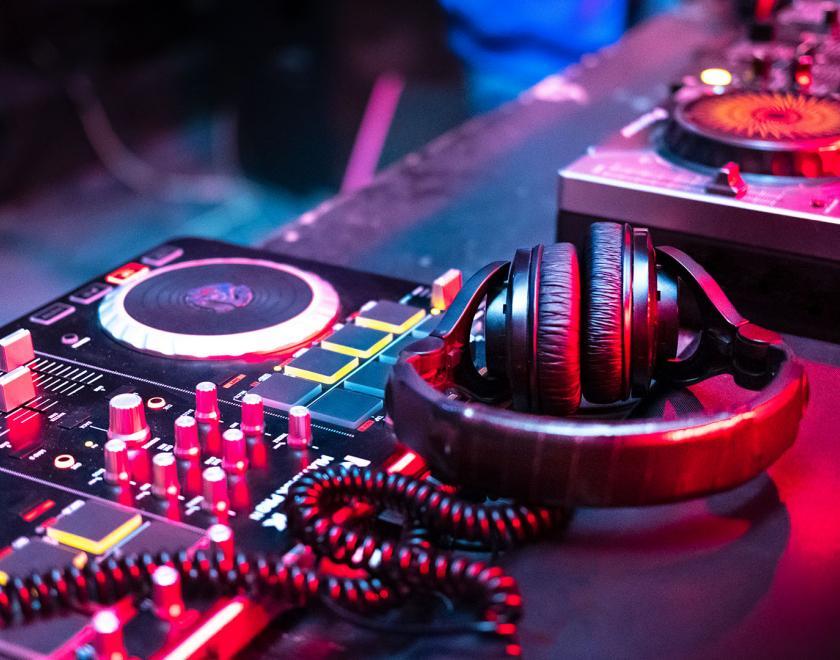 Stock image of mixing desk and headphones bathed in blue and pink lights