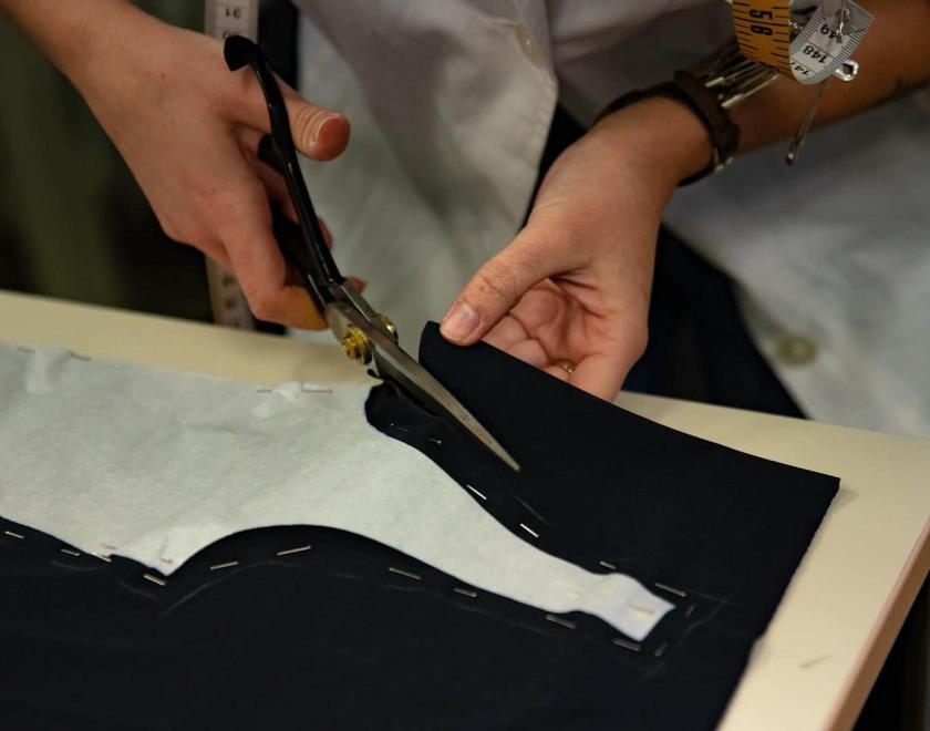 Person cutting a garment with scissors