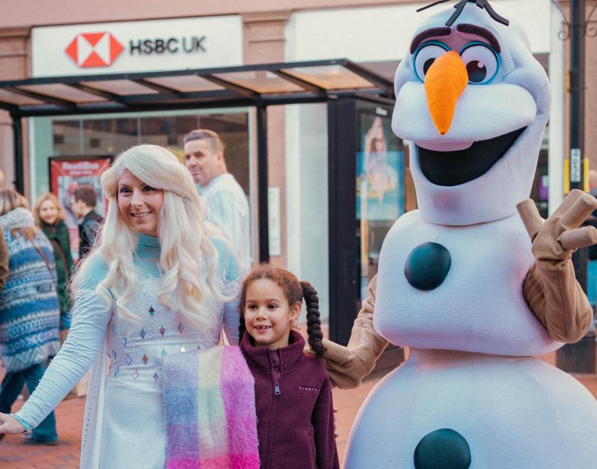 Snow Queen and Huggable Snowman with a child on Broad Street