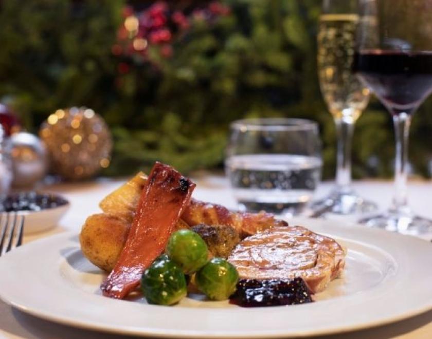 The image shows a roast dinner on a plate. There's a Christmas tree in the background.