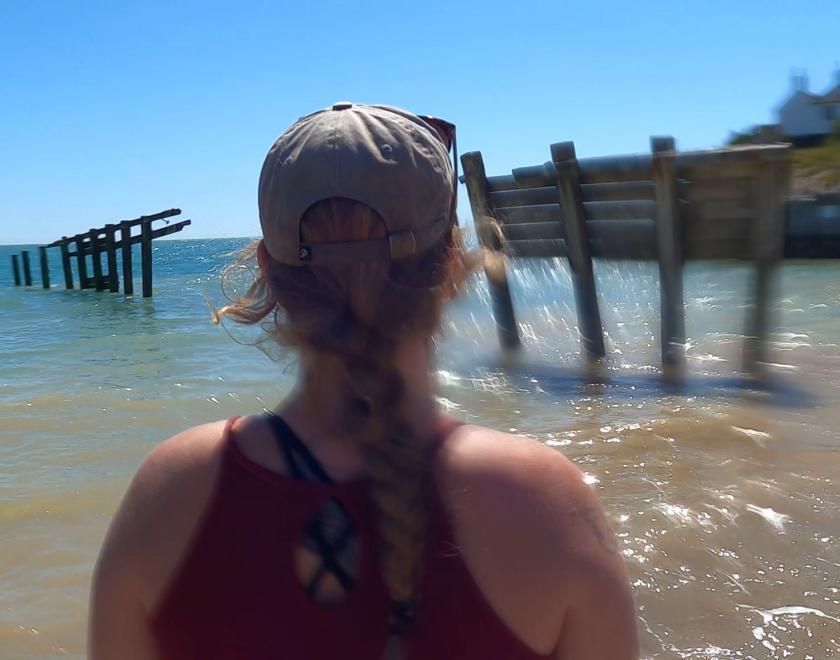 Woman standing by the sea with her back to the camera