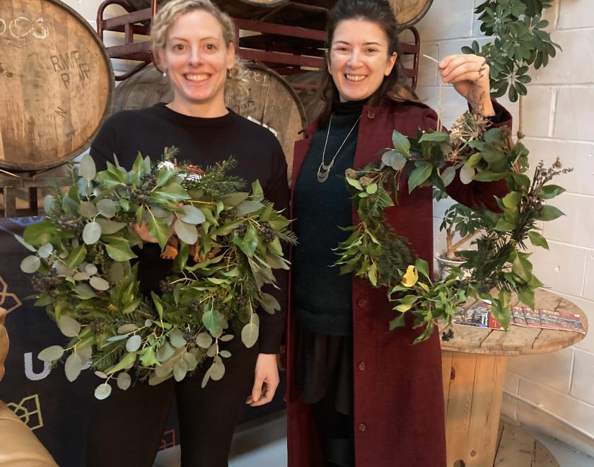 2 women proudly holding natural Christmas wreaths at Double Barrelled Taproom Tilehurst Reading