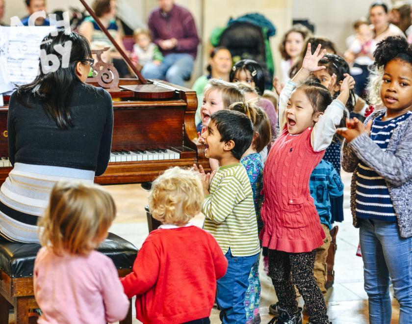 Pianist surrounded by children