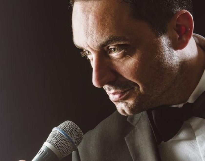 The image shows a close up of a Michael Buble tribute artist singing into a microphone.