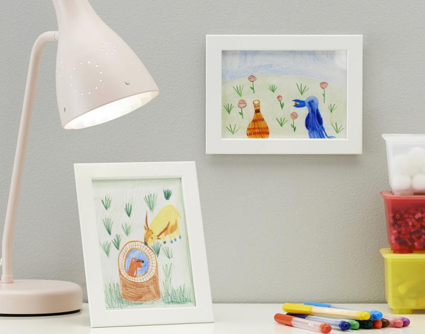 Desk of photo frames with drawn pictures inside 