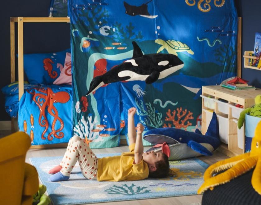 Child laying in their ocean themed bedroom 