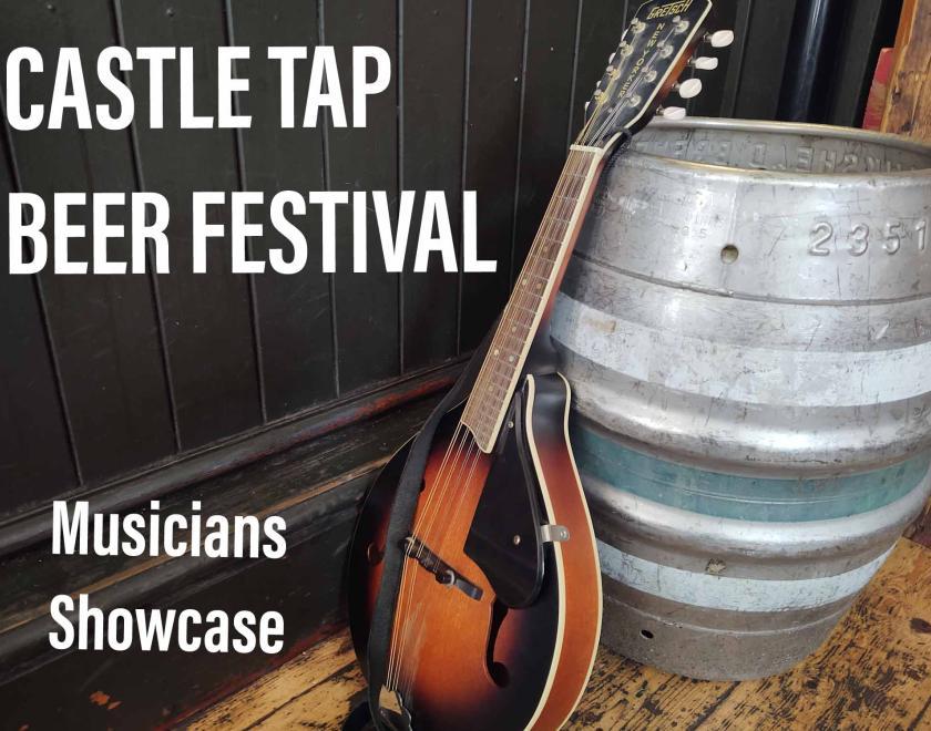 Mandolin leaning against a metal beer firkin on pale wooden floor with dark wooden panelling  to the left side