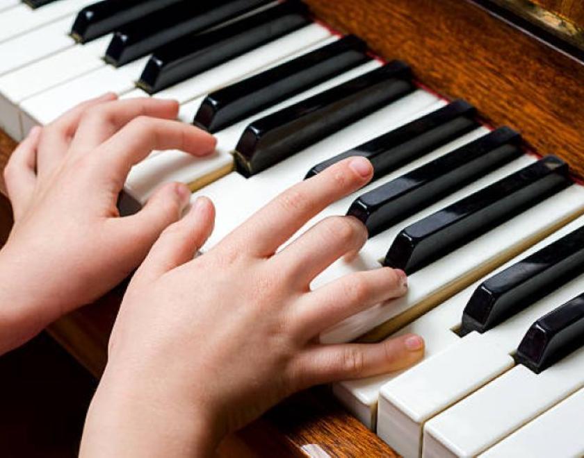 Child hands playing piano