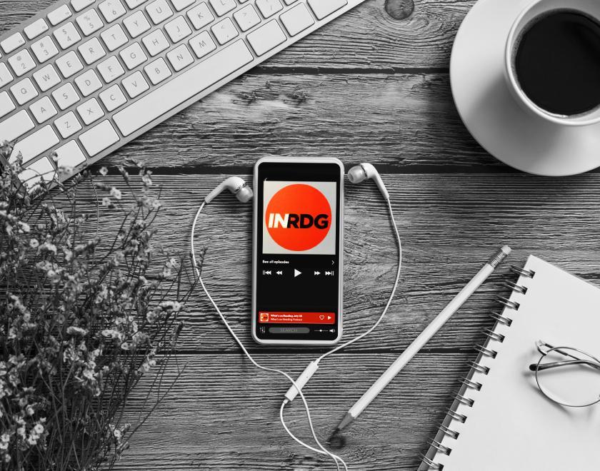 Desk with smartphone tuned to What's On Reading podcast