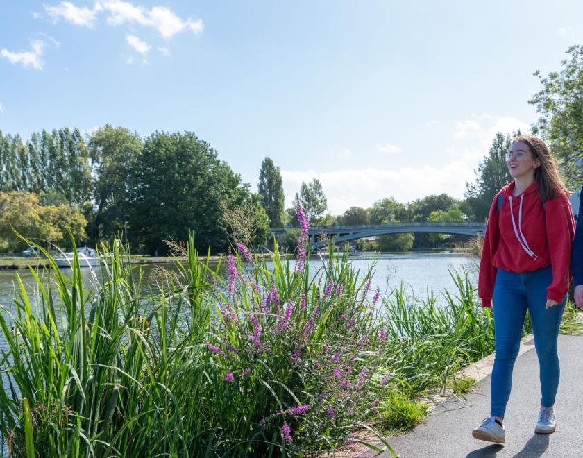 Two girls walking beside a river