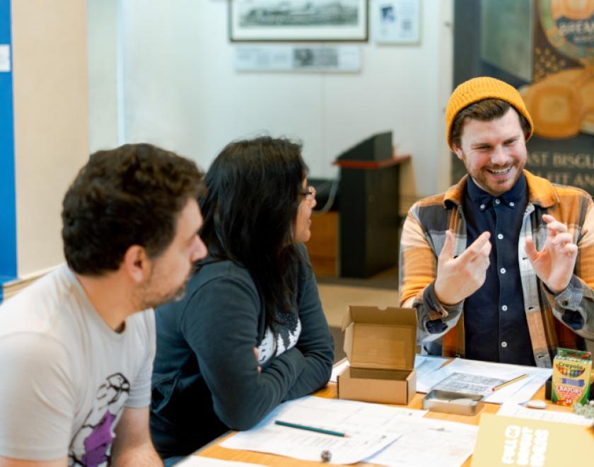 Group of young people sat around a table playing dungeons and dragons