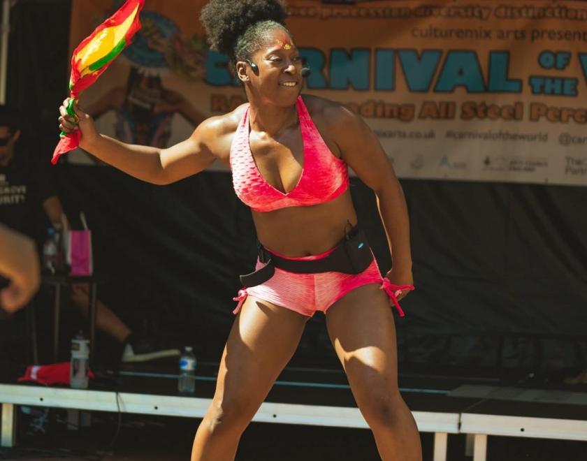 Soca dance class tutor Krystle waving a flag at a dance workshop 