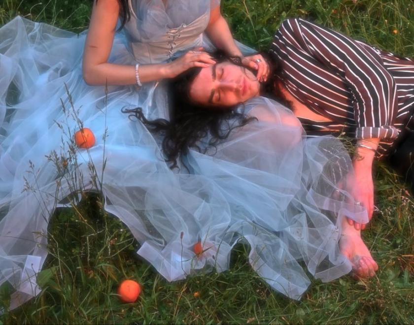 photo of a man and woman lying together in the grass