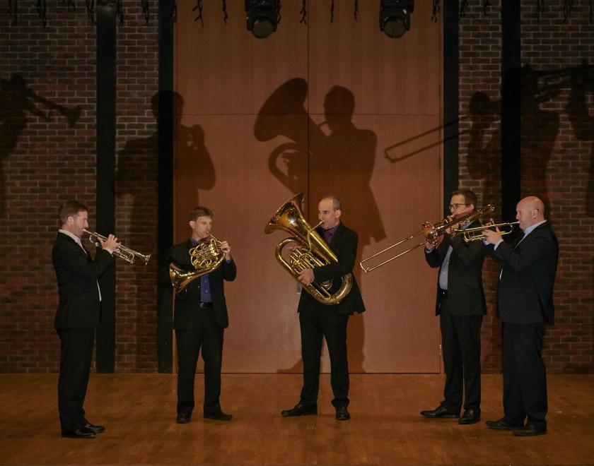 Onyx Brass standing in a semi circle playing