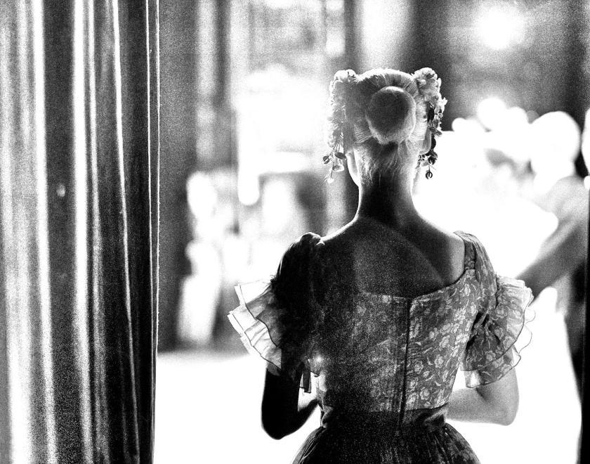 Black and white image of an actress waiting to go on stage