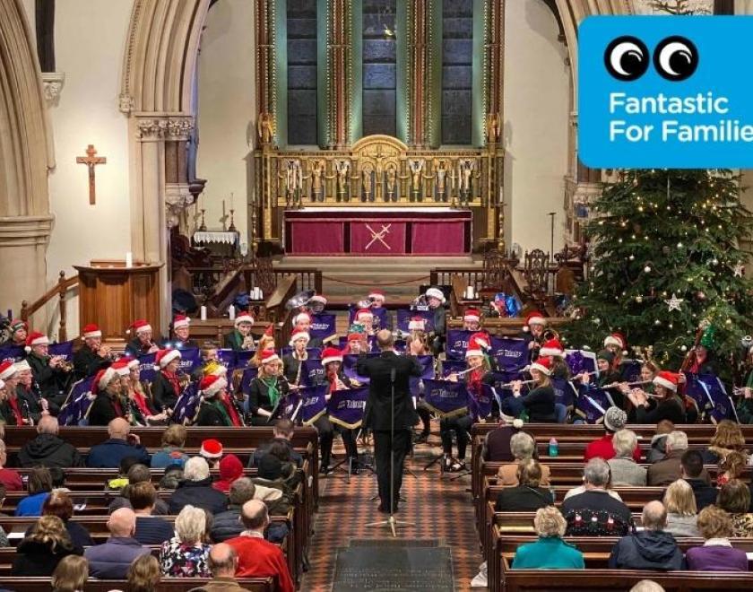 Trinity Concert Band performing at Reading Minster, wearing Christmas hats.
