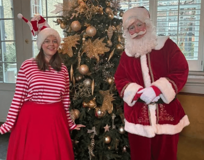 Santa and his Elf beside a Christmas tree