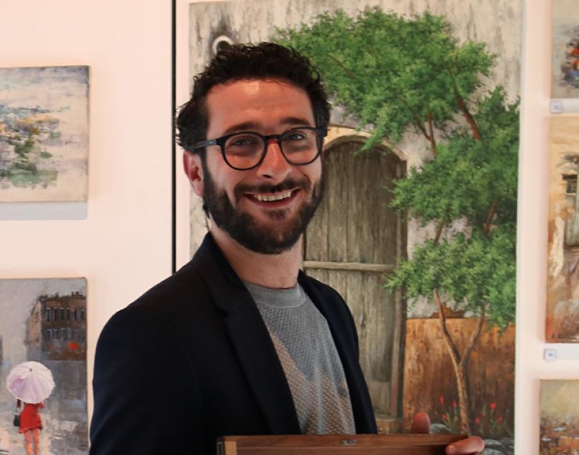 Artist Ahmad Alazami surrounded by his paintings