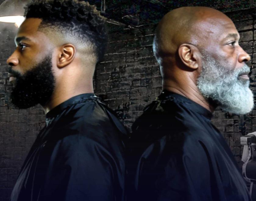 Two black men, back to back, wearing barber's bibs