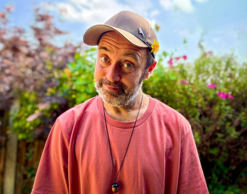 Musician Beans on Toast in a red t-shirt and dirty-white baseball cap