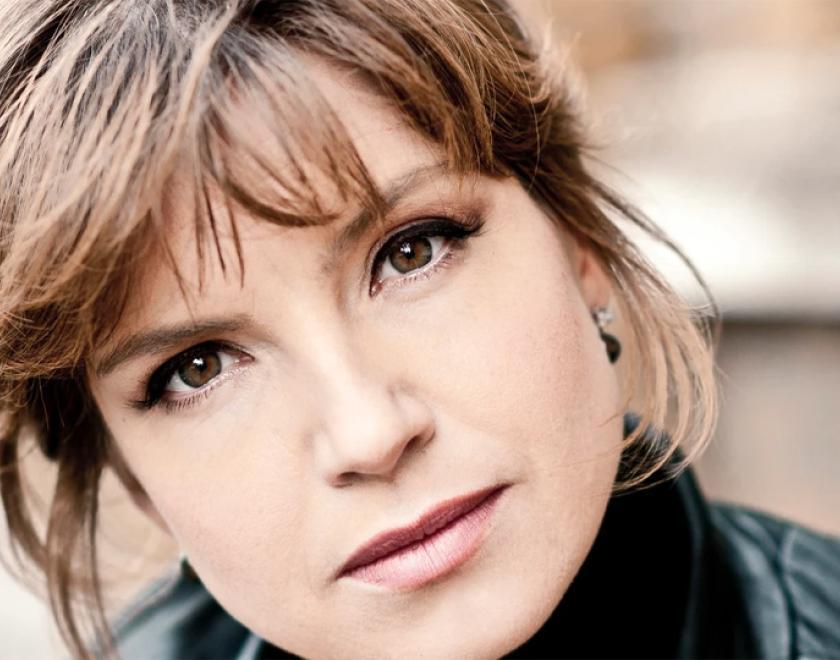 Claire Booth, a woman with brown hair wearing a leather jacket