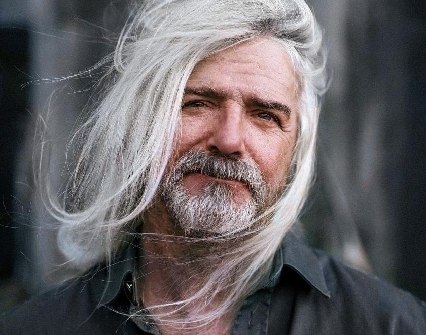 John Bramwell with long white windswept hair and a greying beard