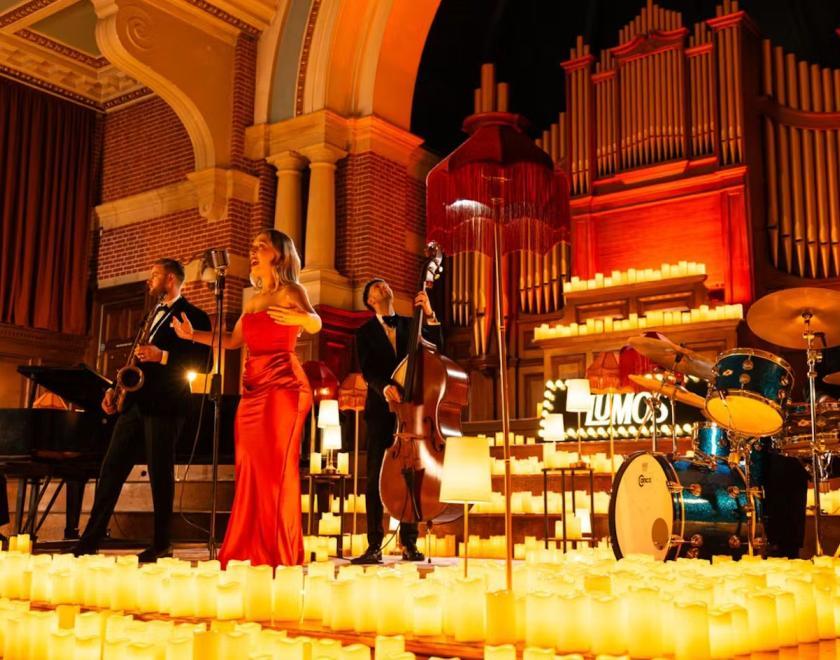 Jazz band performing on stage surrounded by candlelight