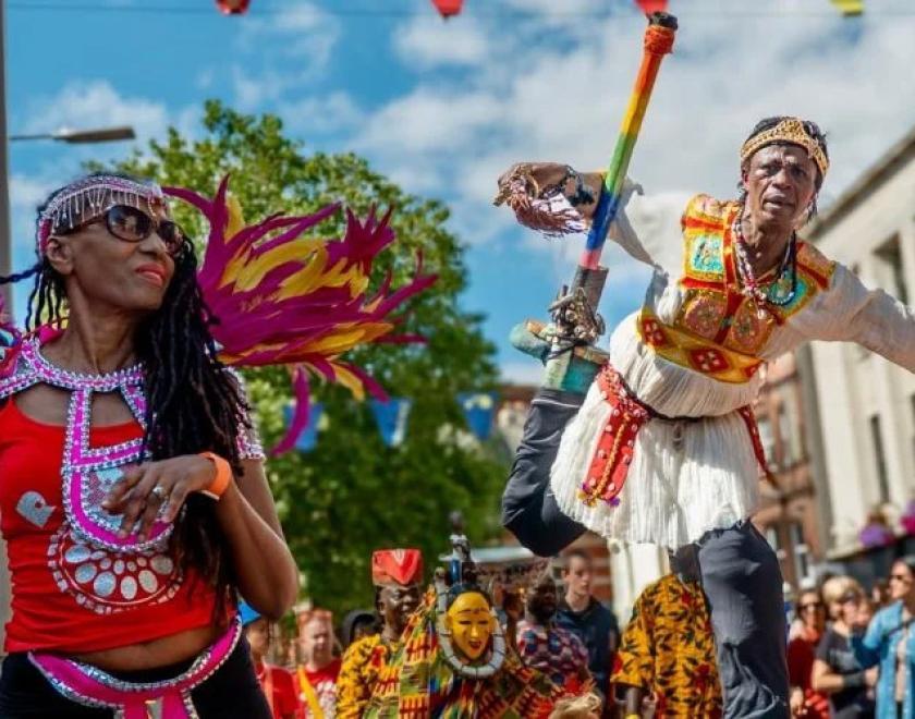 Performers in carnival outfits walking down Broad Street