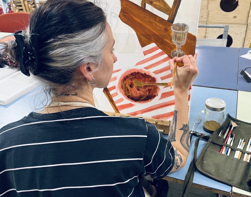 back of woman's head over her painting 